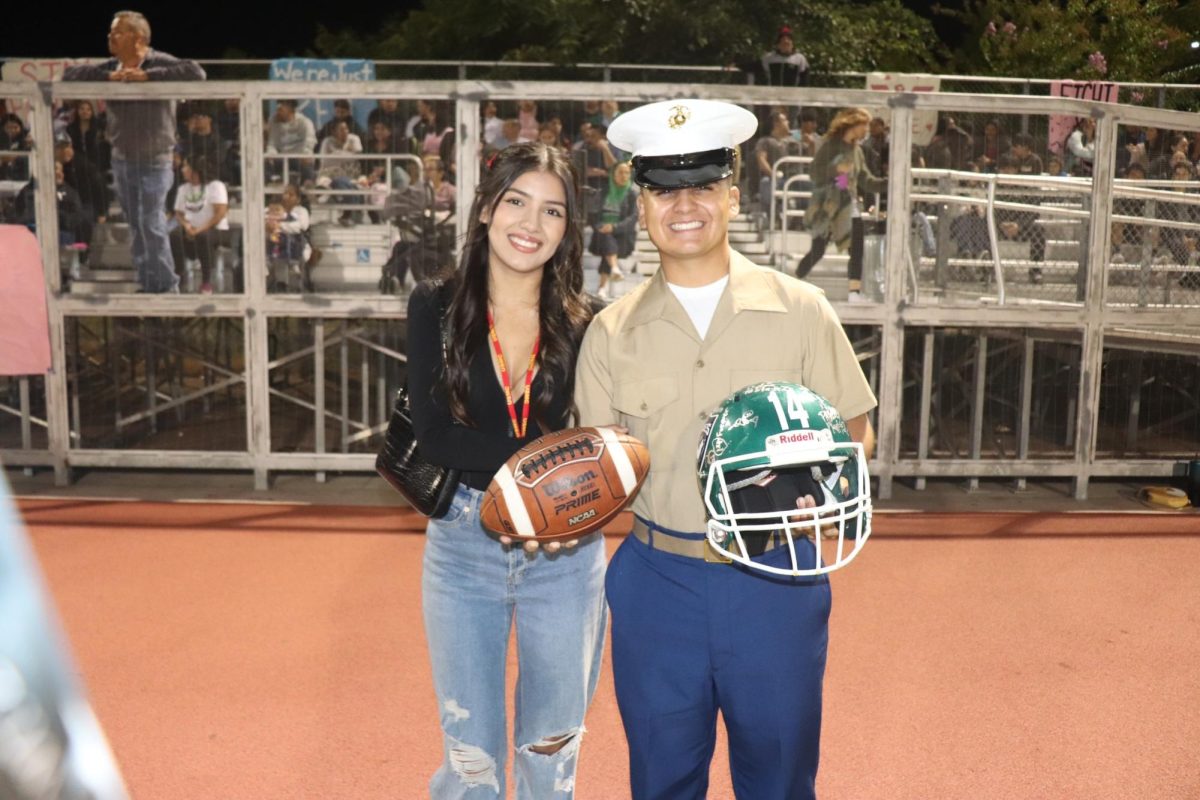 WELCOME BACK - Logan (right) and his girlfriend (left) at home game where he is holding a signed helmet from MACES football team