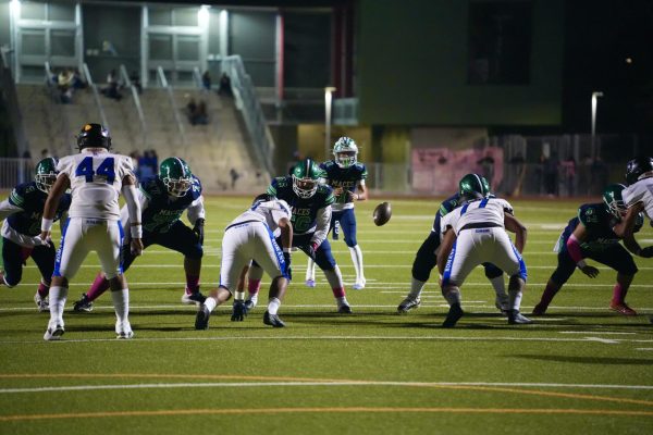 Getting the snap - Quarterback Domenic Angulo starts the play with a snap from center Aaden Arrieta just before the start of halftime.