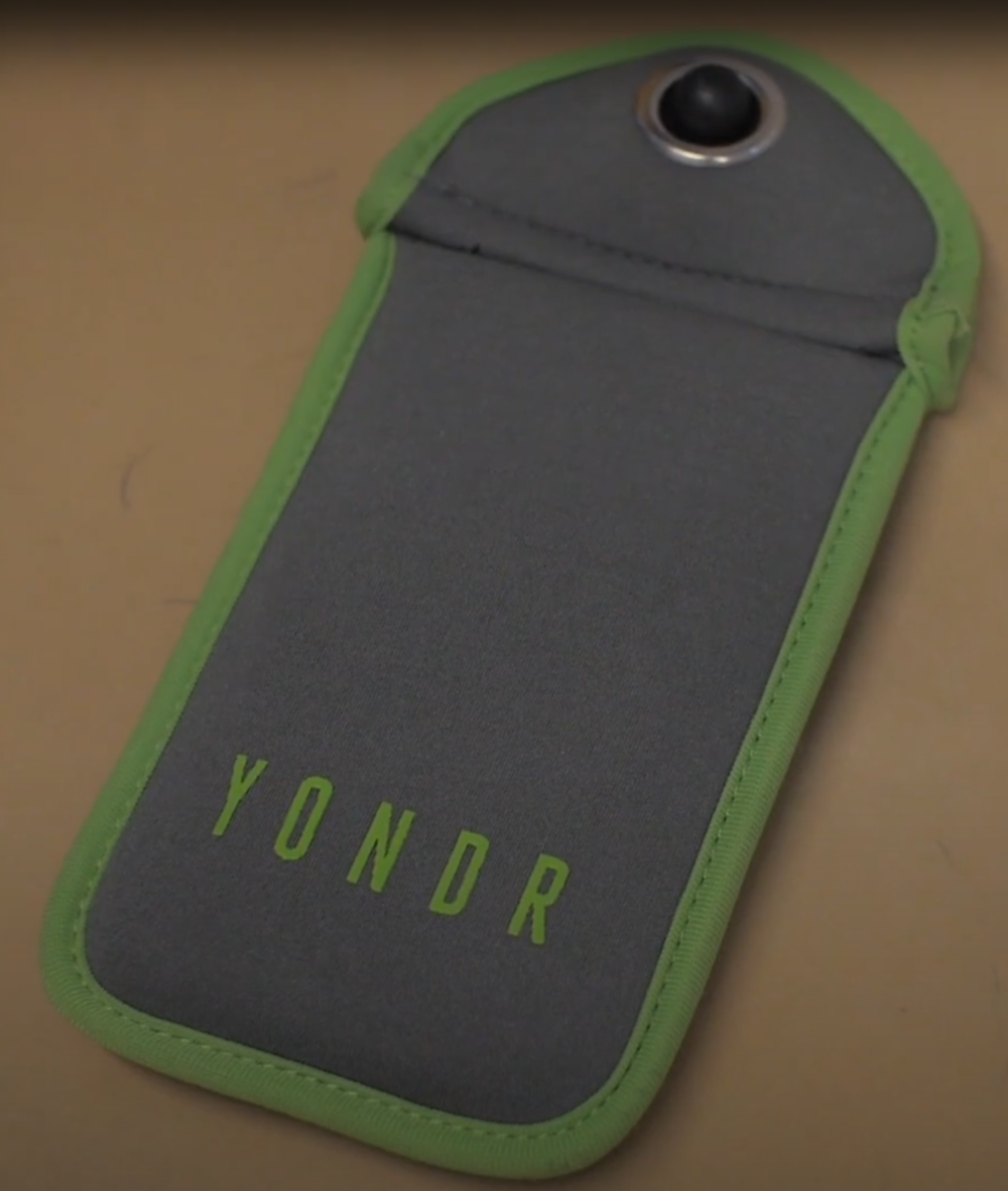 A Yondr pouch, a polarizing item in school campuses, rests on a tabletop. While some administrators support its use, many students are against it, arguing it limits vital communication.