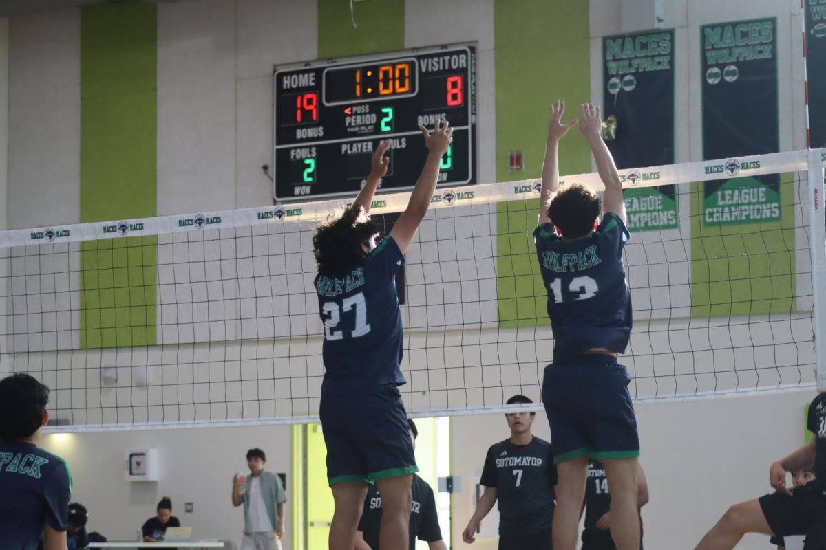 Going up strong, Hands up at the net as defenders rise to stop the attack. 
Two players jump with their hands extended in the air attempting to block the ball during a match.
The team had been working on strengthening their hitting and blocking during practices leading up to league play.“Some strengths we have are good hitting from outside, middles and opposite hitters. We also have a lot of tall people that are able to block the ball,” Cruz said.
