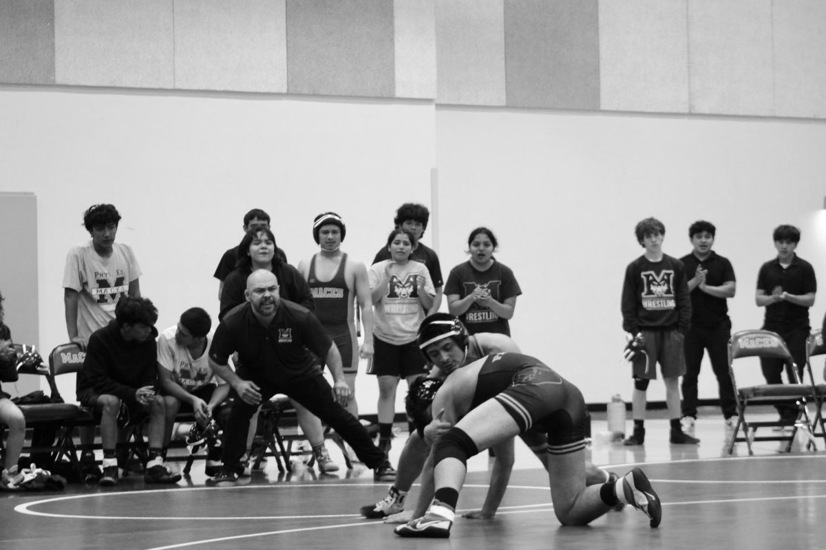 A maces wrestler battles on the mat, taking to take over the match and get a win for his team.